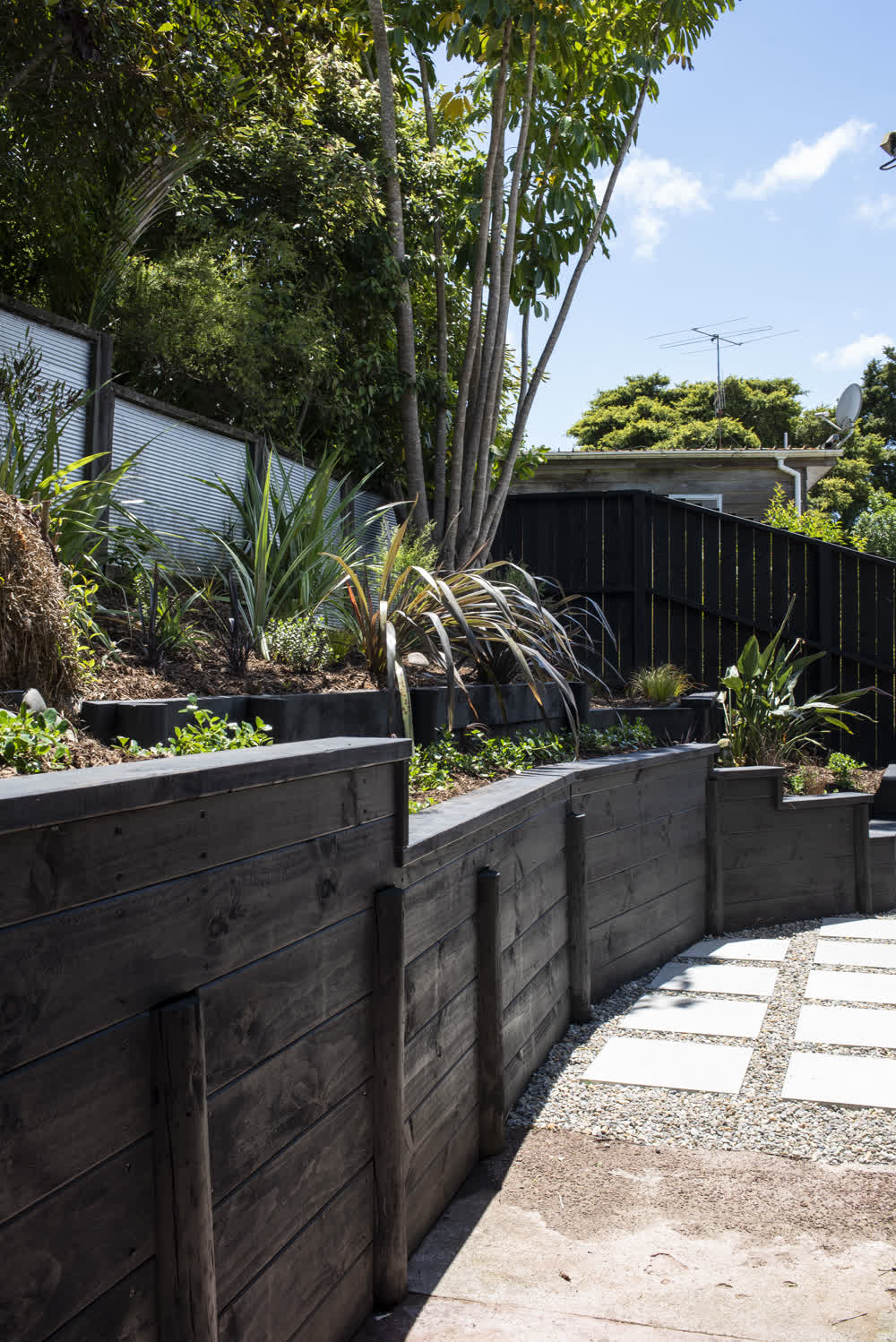 Tiered timber retaining wall leading to fence line